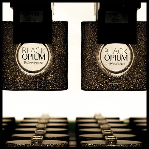 Two bottles of Yves Saint Laurent Black Opium perfume on a production line.