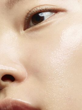 Close-up of a person's nose and lips with a dewy complexion.