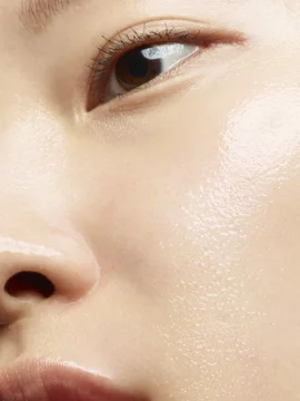 Close-up of a person's nose and lips with a dewy complexion.