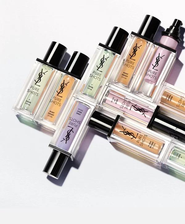 Multiple bottles of YSL Pure Shots serums arranged on a white surface.