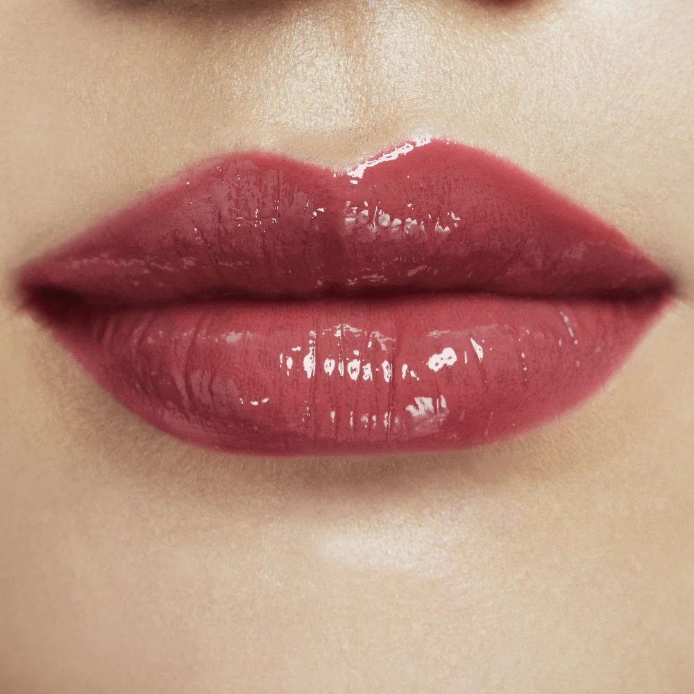 Close-up of lips with a glossy red lipstick.