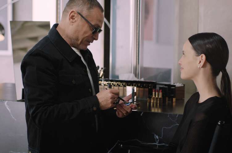 A person applying makeup to another person.