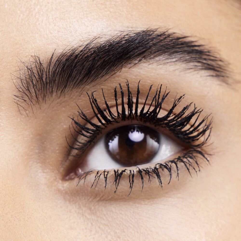 Close-up of an eye with long, voluminous eyelashes and well-groomed eyebrows.