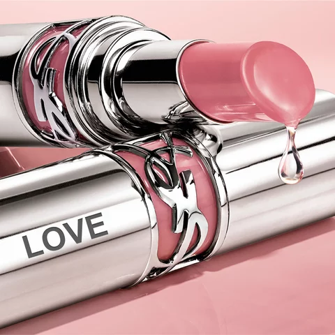 Close-up of YSL lipstick with a drop of liquid on the tip.