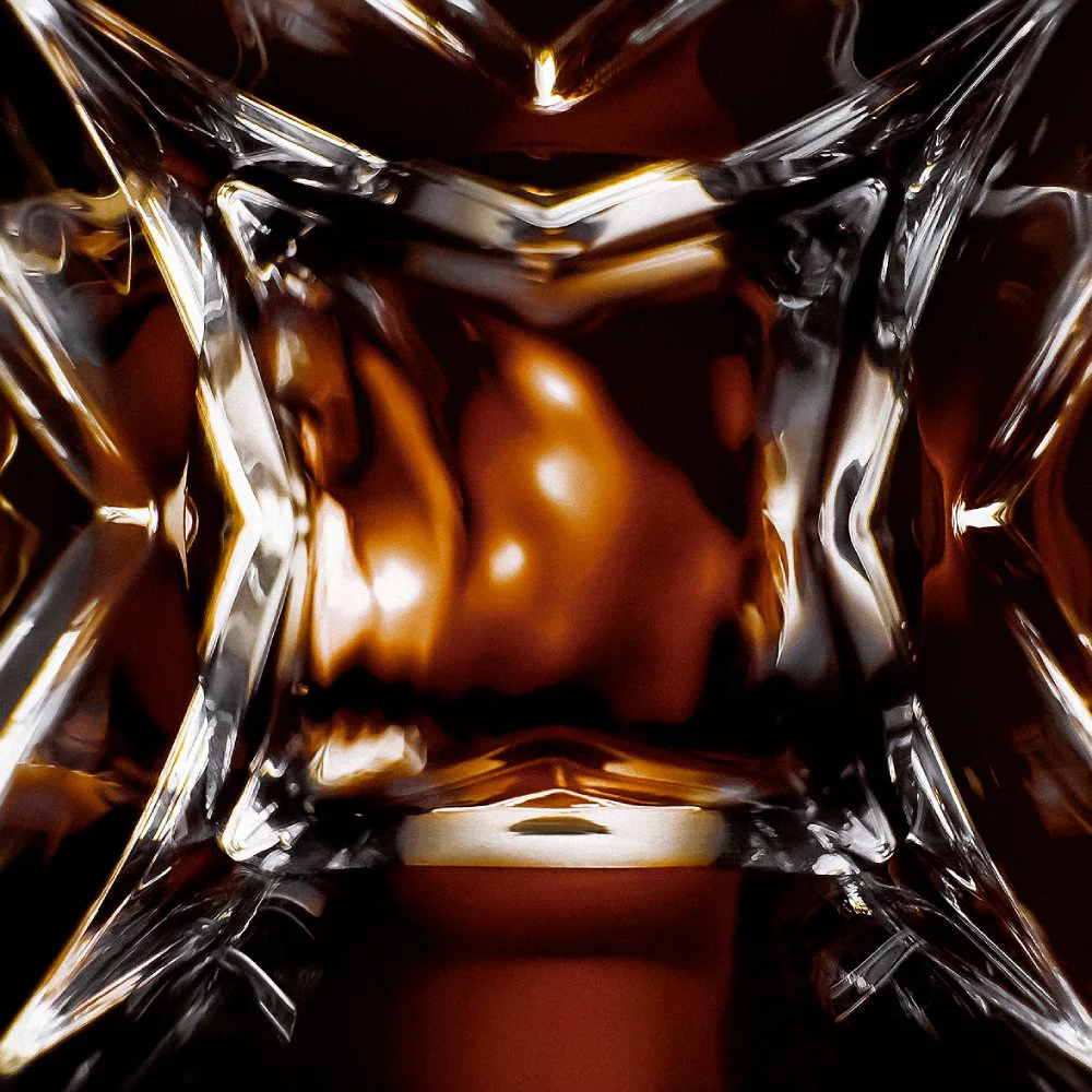 YSL LVDP Tuxedo Extrait de Parfum bottle, extreme close-up of the intricate glass design with luminous reflections.