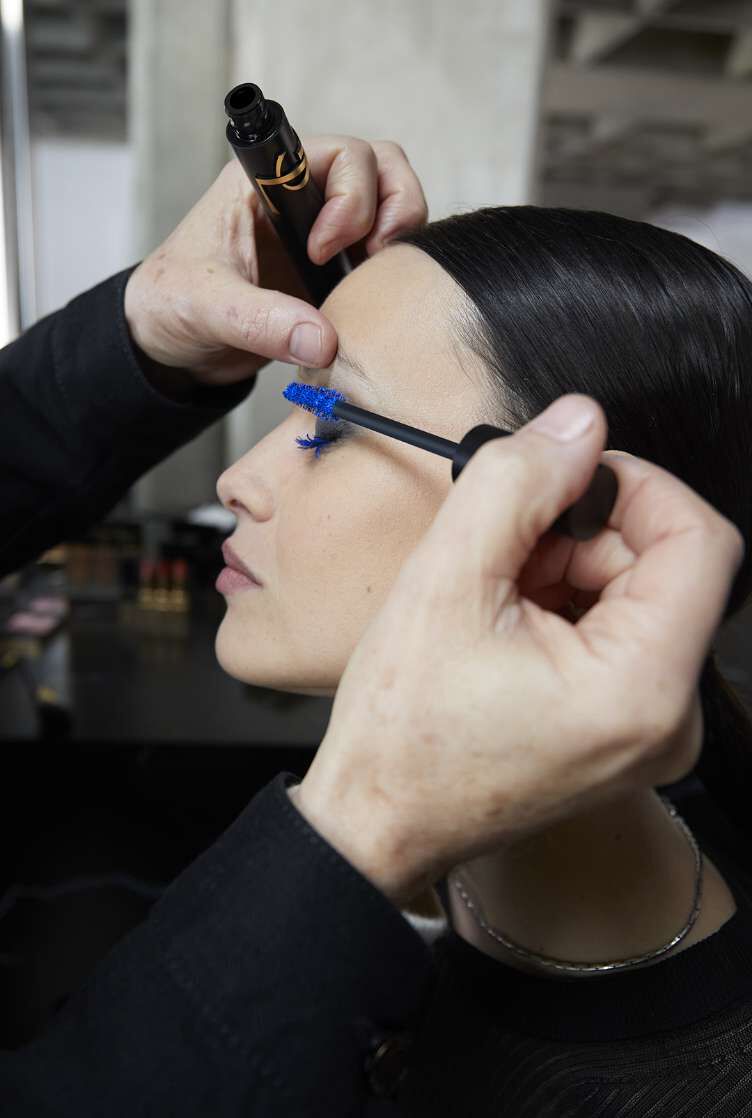 Person applying makeup with a YSL product.
