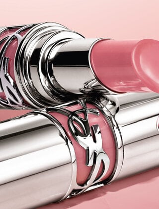 Two YSL lipsticks with a pink background, one with a droplet.