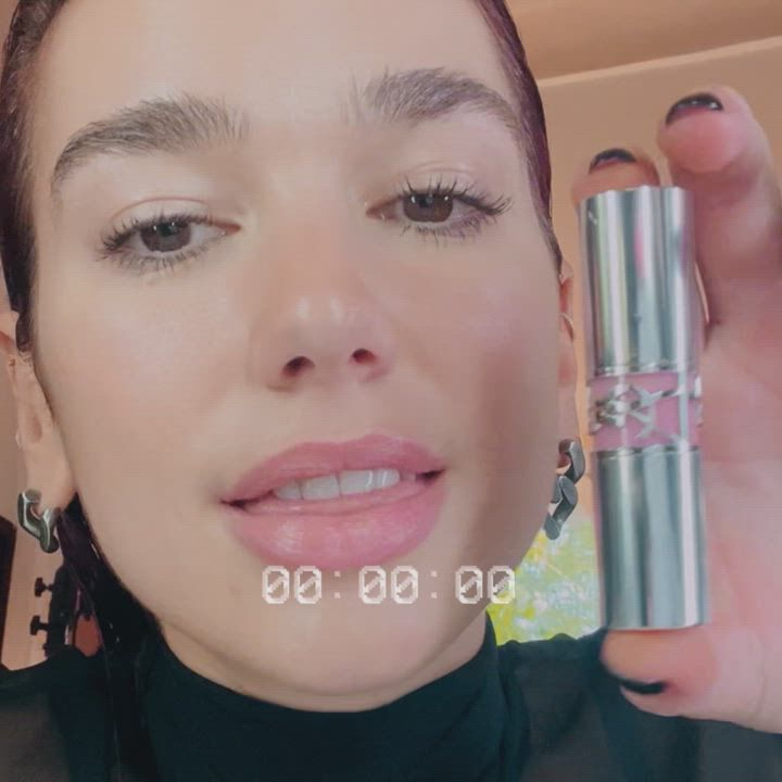 A person holding a silver YSL product with pink details.