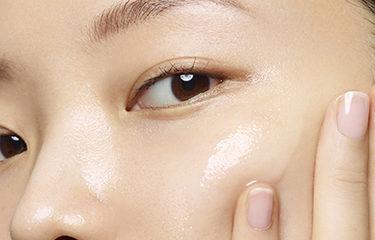 A person with a manicured hand touching their face.