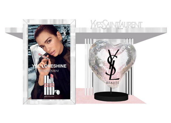 YSL LOVESHINE display with a person holding a lipstick and a heart-shaped YSL logo.