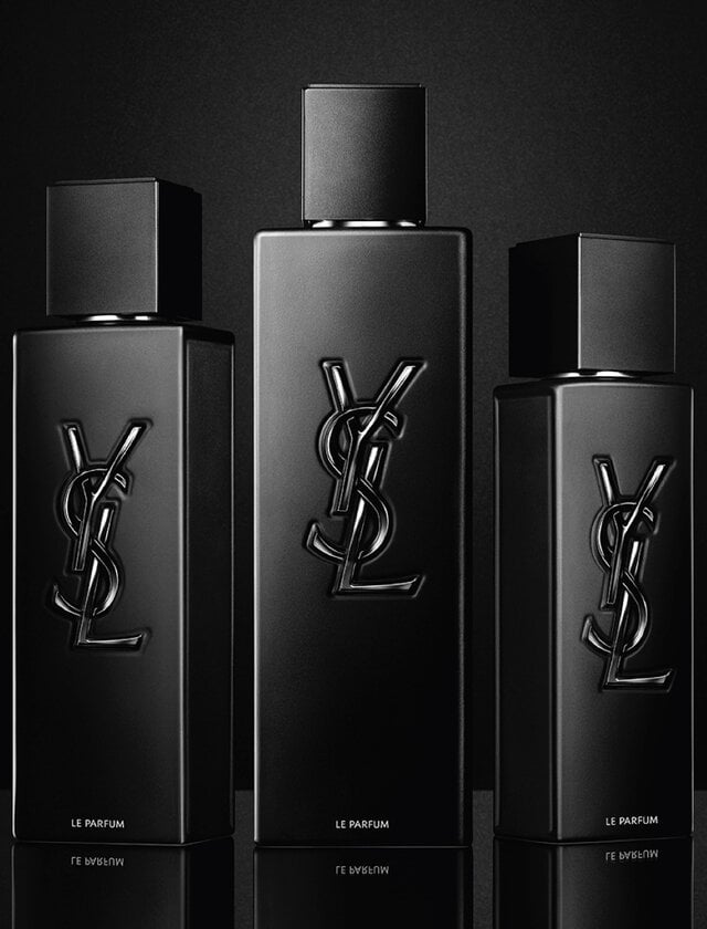 Three black YSL perfume bottles on a black background.
