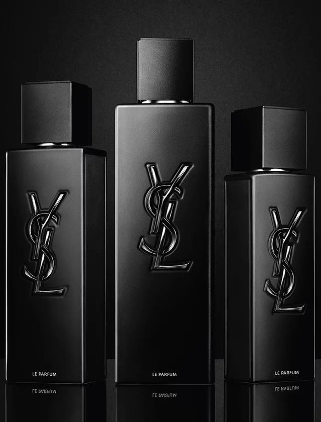 Three black YSL perfume bottles on a black background.