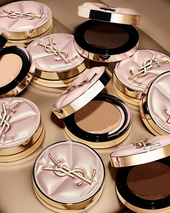 YSL SKIN AFFAIR CUSHION cases in a taxi cup holder with a glass of water. Luxury on-the-go hydration and soft glow.