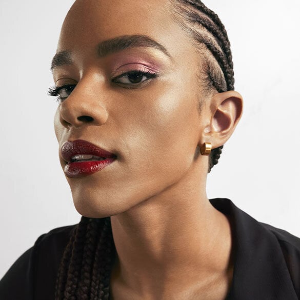 Close-up of a person with braided hair wearing a black top.