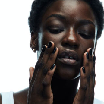 Close-up of a person with hands on their face.