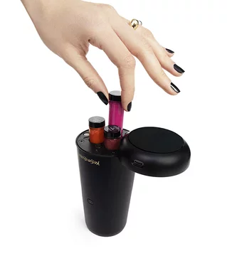 A hand placing a vial into a black YSL device.