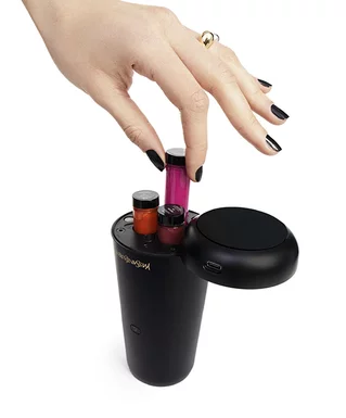 A hand placing a vial into a black YSL device.