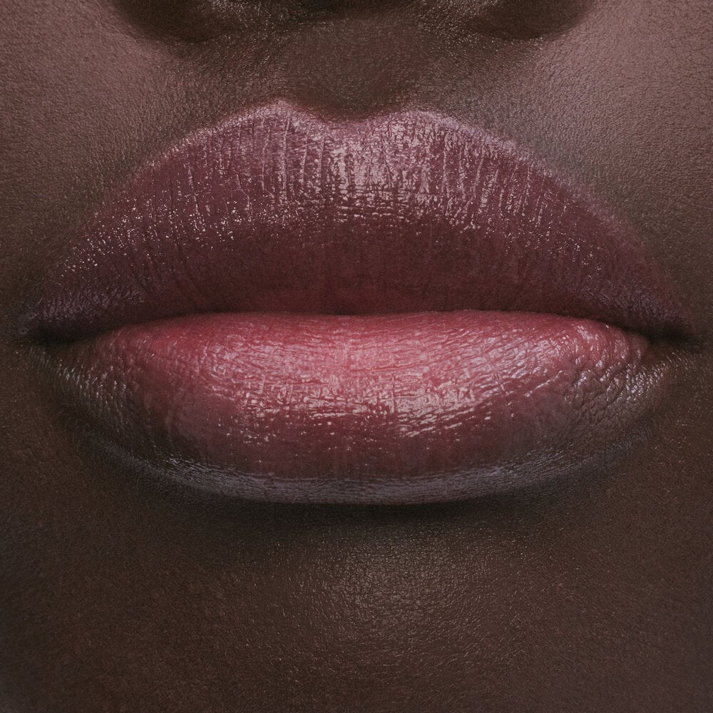 Close-up of lips with a glossy, deep pink lipstick.