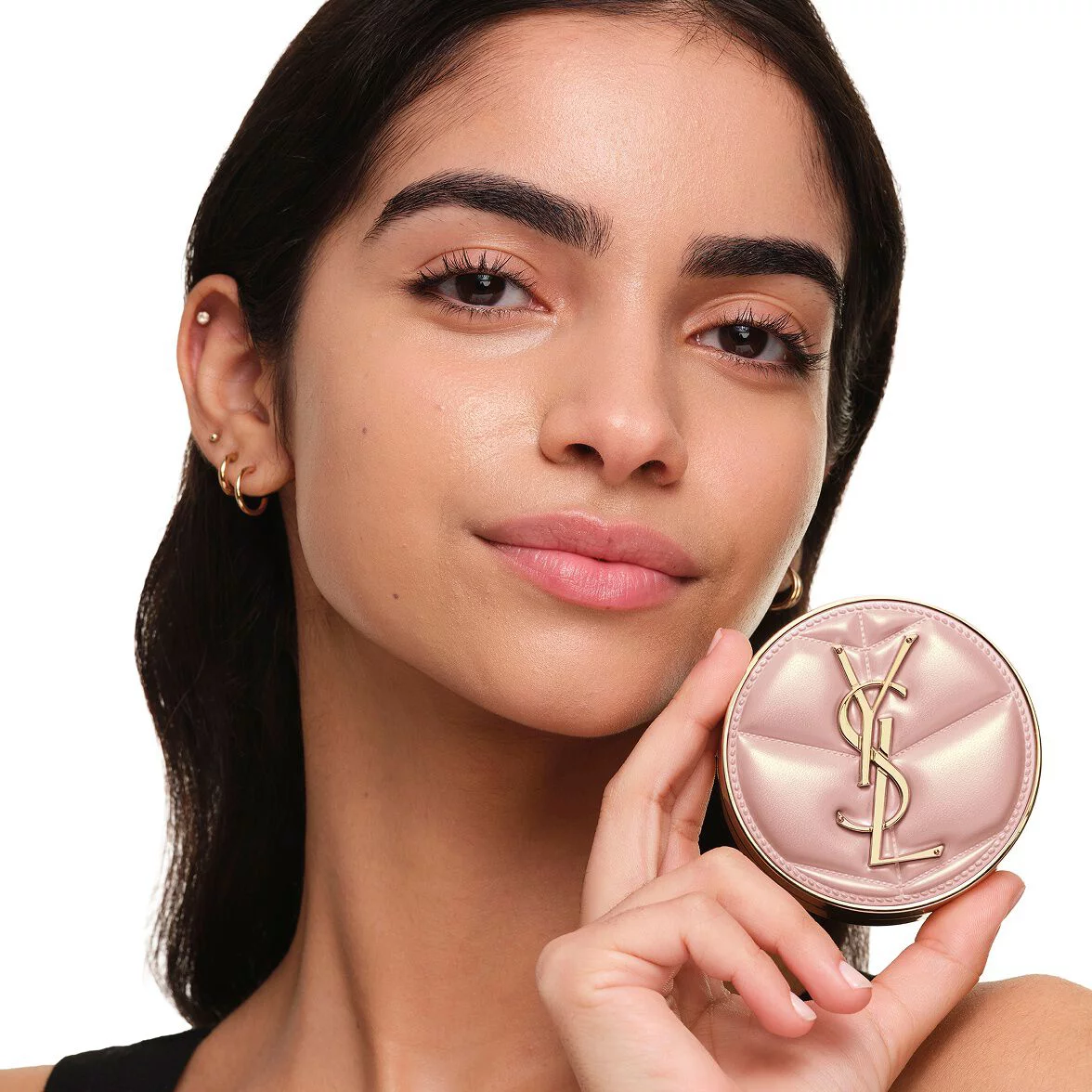 Model with medium skin holding YSL SKIN AFFAIR SOFT GLOW CUSHION. Radiant, unified and natural-looking complexion.