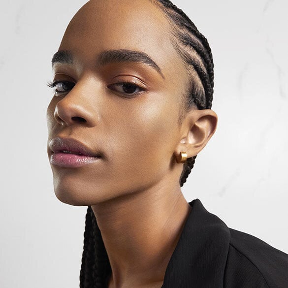 Close-up of a person with braided hair and a black top.
