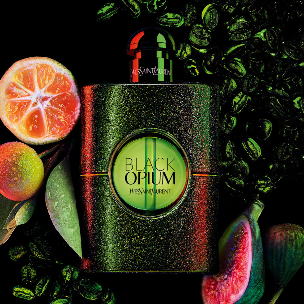 YSL Black Opium perfume bottle surrounded by citrus fruits, figs, and coffee beans.