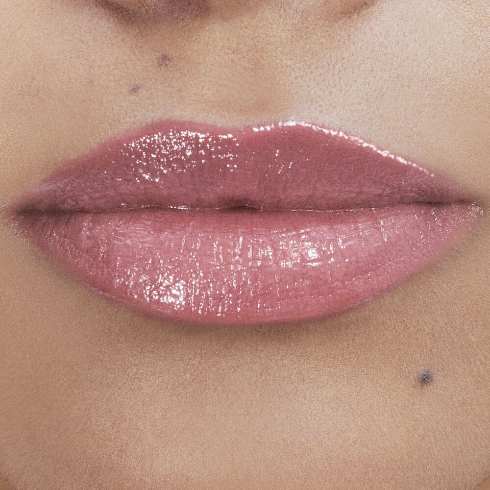 Close-up of lips with glossy pink lipstick.