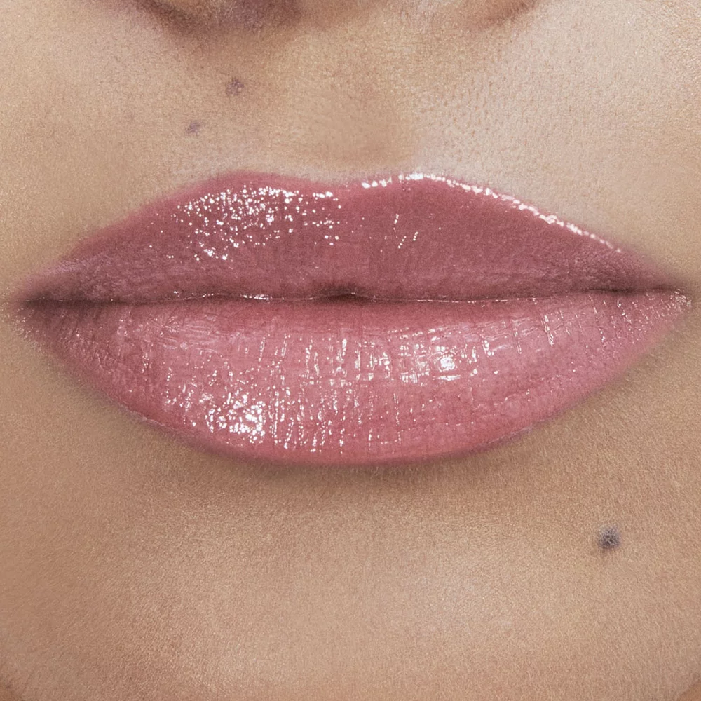 Close-up of lips with glossy pink lipstick.