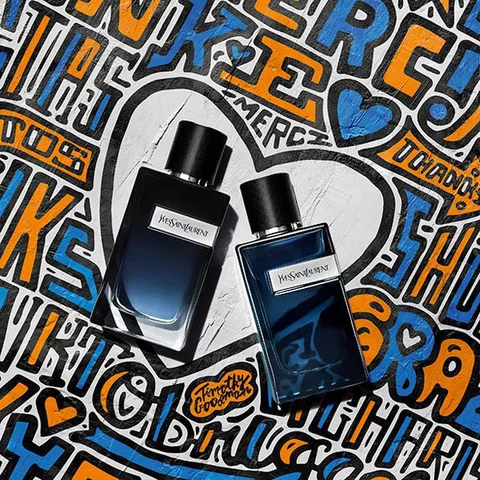 Two bottles of YSL cologne on a colorful graffiti background.