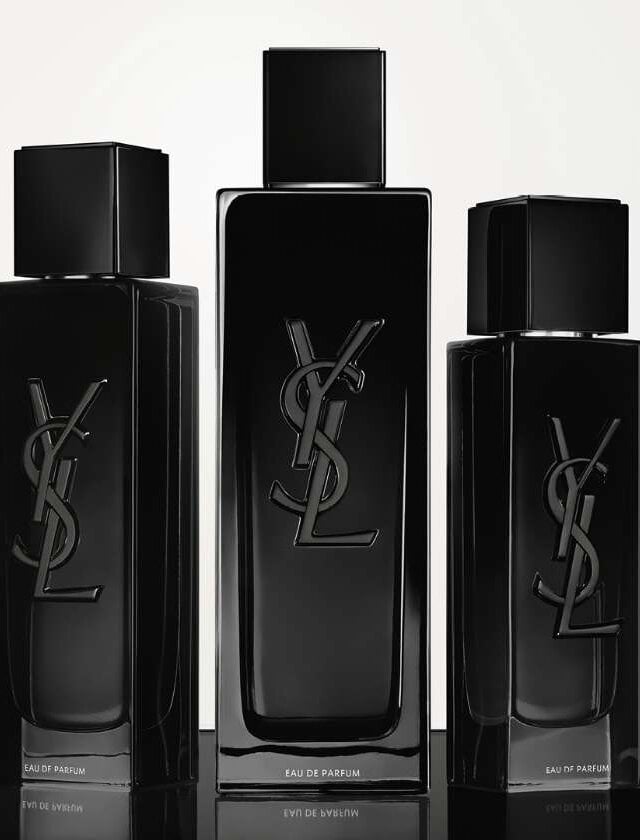 Three black YSL perfume bottles of different sizes on a reflective surface.