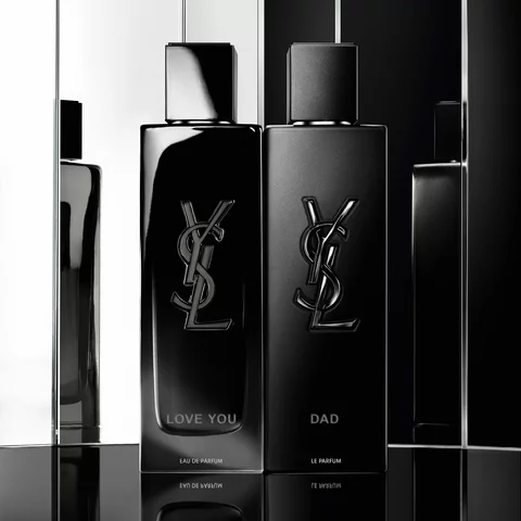 Two black Yves Saint Laurent perfume bottles, one labeled 'LOVE YOU' and the other 'DAD.'