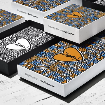 Yves Saint Laurent x Timothy Goodman designed boxes with colorful text and heart illustrations.