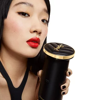 A woman holding the YSL Rouge Sur Mesure Custom Lip Color Creator