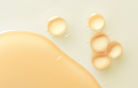 Close-up of beige and orange liquid drops.