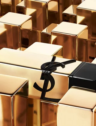 A black YSL lipstick tube surrounded by gold blocks.