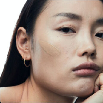 Close-up of a woman's ear with a gold hoop earring.