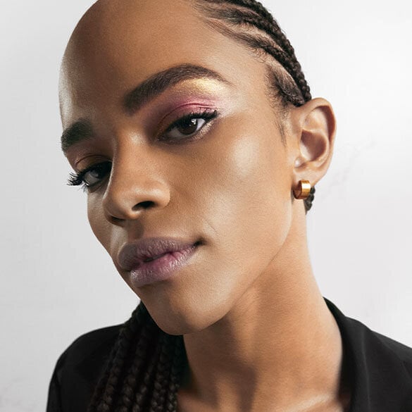 Close-up of a person with braided hair wearing a black top.