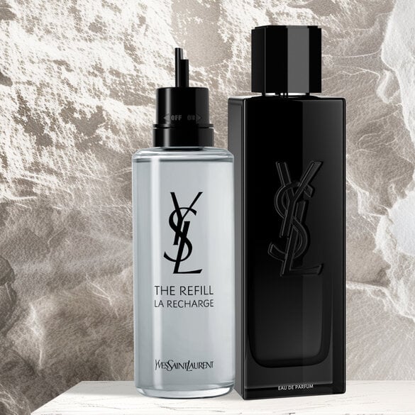 Two YSL perfume bottles, one black and one clear, against a textured background.