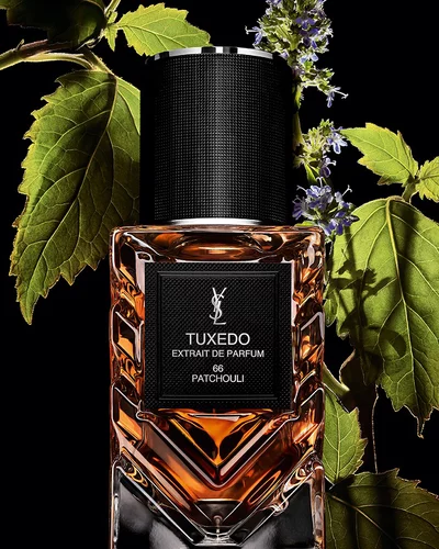 YSL LVDP Tuxedo Extrait de Parfum bottle, adorned with vibrant green patchouli leaves and delicate purple flowers.