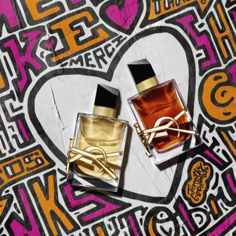 Two bottles of YSL perfume on a colorful graffiti background.