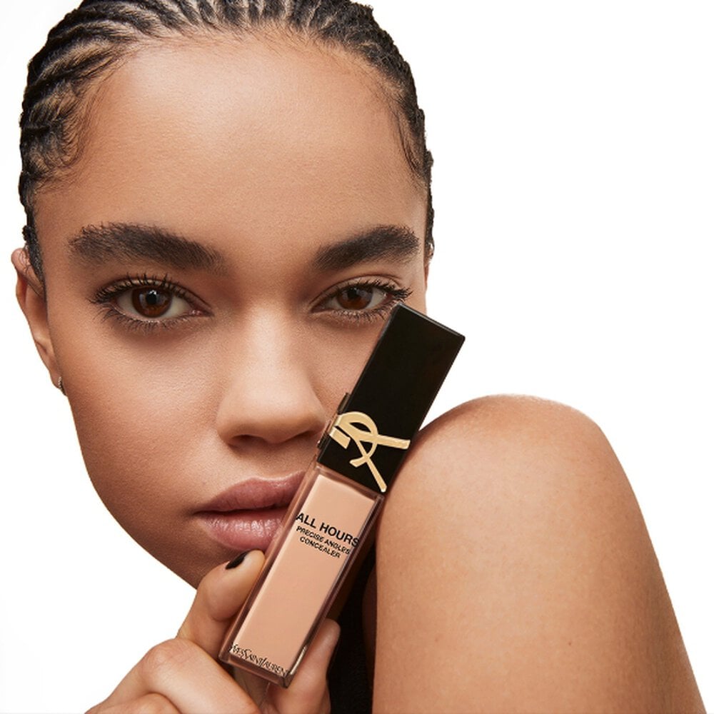 Person holding a YSL product near their face.