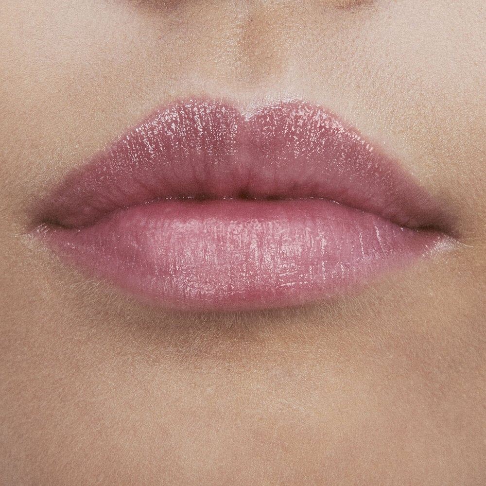 Close-up of lips with glossy pink lipstick.