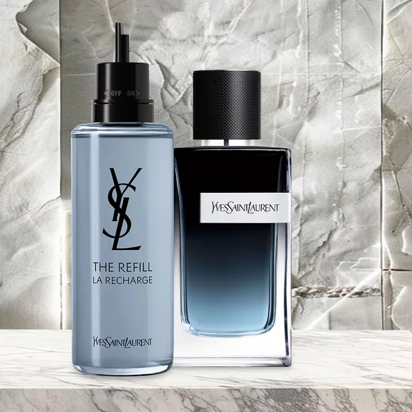 YSL The Refill La Recharge bottle and Yves Saint Laurent perfume bottle on a marble surface.