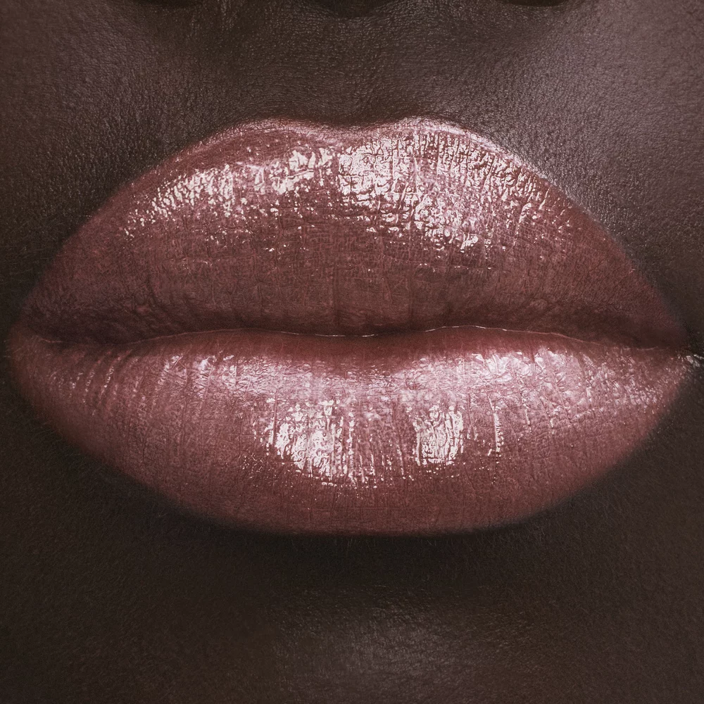Close-up of lips with glossy pink lipstick.