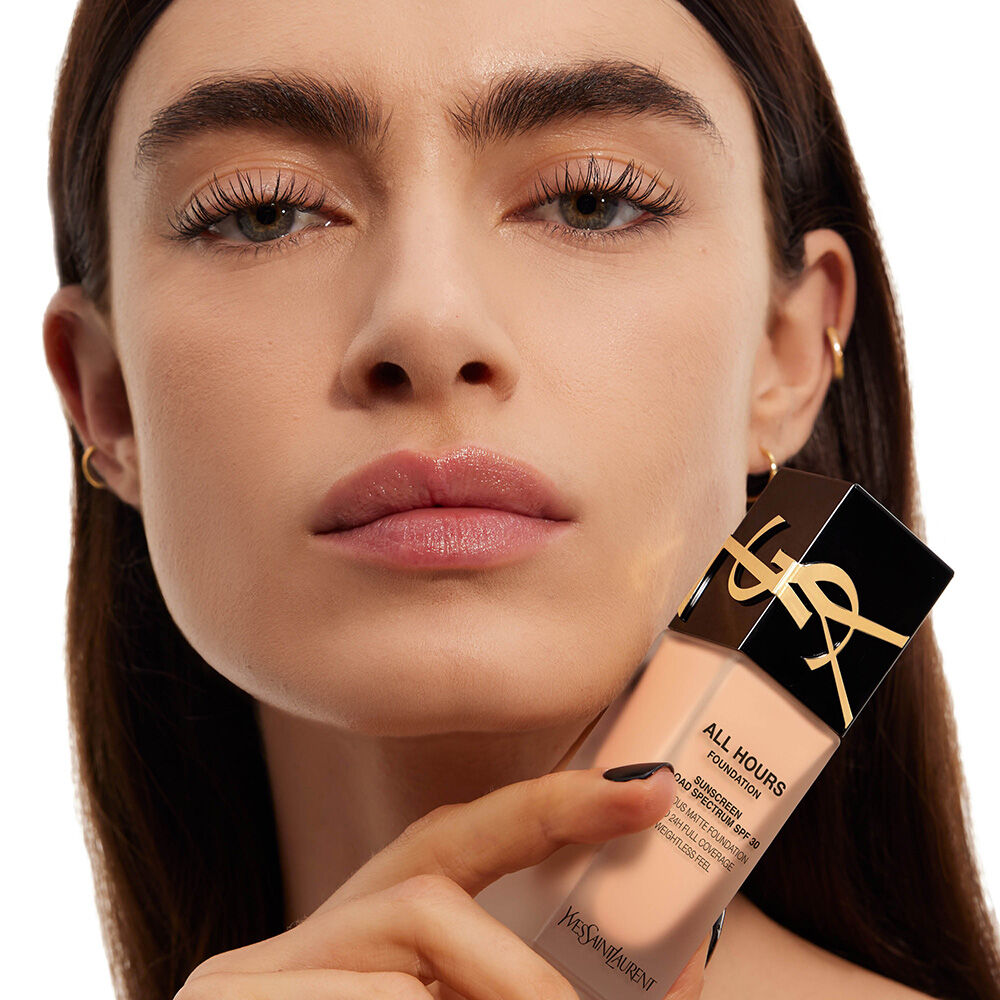 Close-up of model holding All Hours Foundation bottle