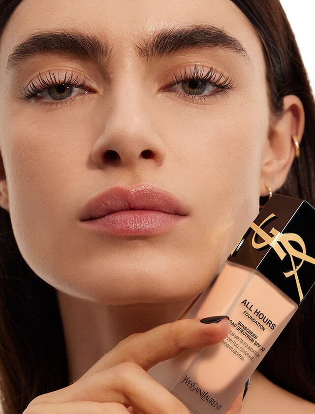 Close-up of model holding All Hours Foundation bottle