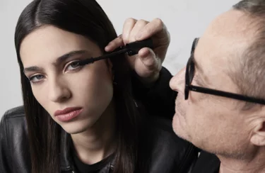 A person applies makeup to another person.