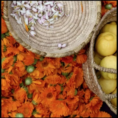 Baskets of flowers and lemons on a bed of orange flowers.