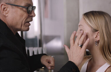 A person applying makeup to another person.