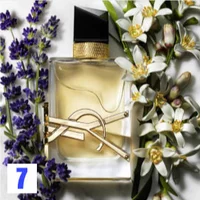 Rectangular YSL perfume bottle with amber liquid, surrounded by lavender and white flowers.
